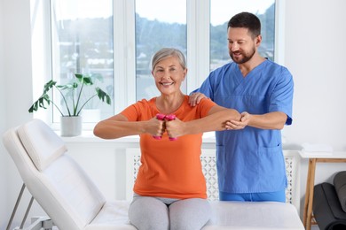 Photo of Senior patient exercising under physiotherapist supervision in rehabilitation center