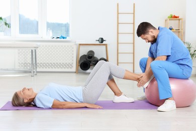 Physiotherapist working with senior patient in rehabilitation center