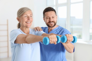 Senior patient exercising under physiotherapist supervision in rehabilitation center