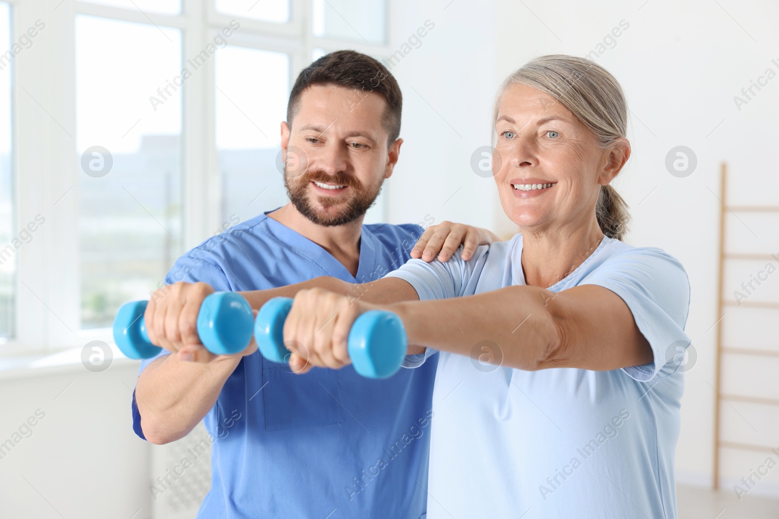 Photo of Senior patient exercising under physiotherapist supervision in rehabilitation center