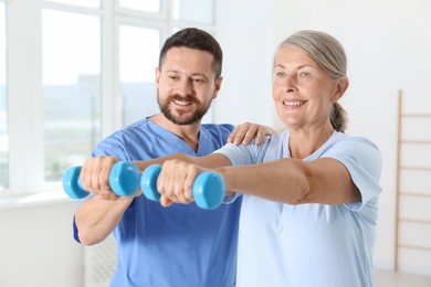 Senior patient exercising under physiotherapist supervision in rehabilitation center