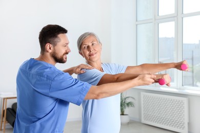 Photo of Senior patient exercising under physiotherapist supervision in rehabilitation center