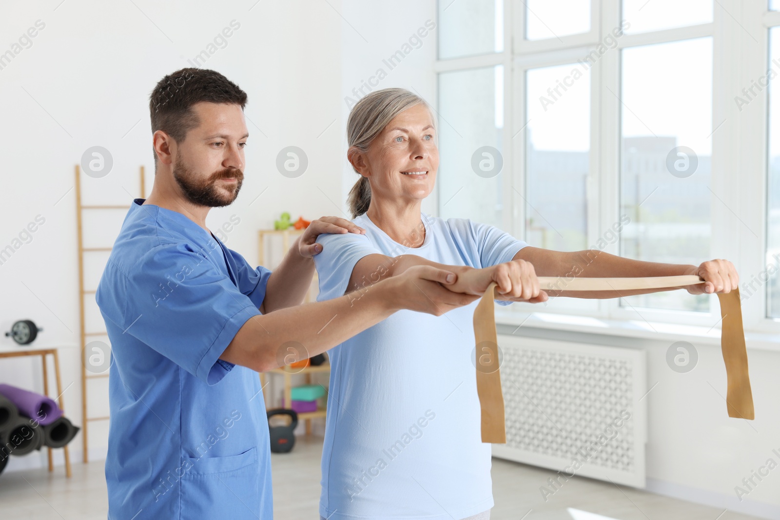 Photo of Senior patient exercising under physiotherapist supervision in rehabilitation center