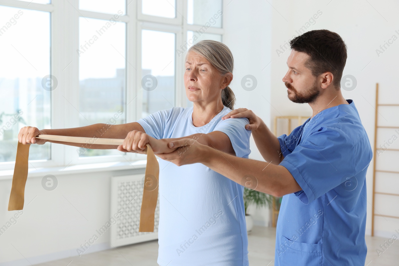 Photo of Senior patient exercising under physiotherapist supervision in rehabilitation center