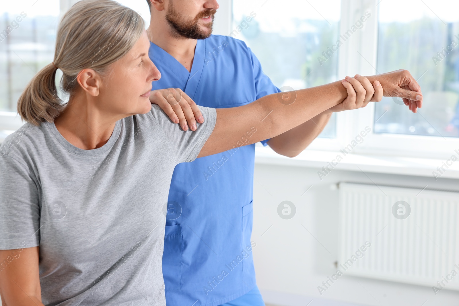 Photo of Physiotherapist working with senior patient in rehabilitation center