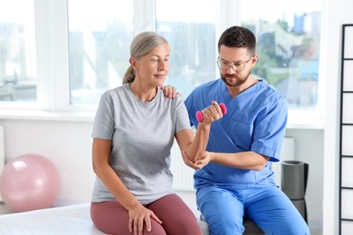 Photo of Senior patient exercising under physiotherapist supervision in rehabilitation center