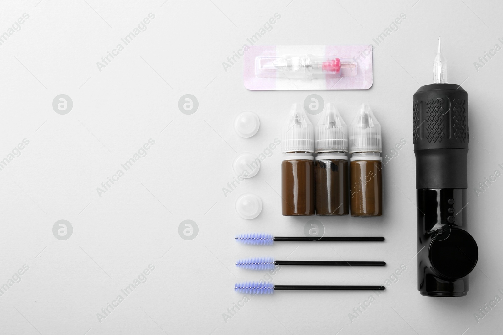 Photo of Permanent makeup equipment kit on light grey background, flat lay