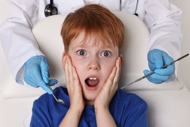 Dental phobia. Dentist working with scared little boy