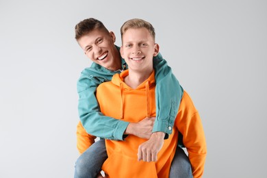 Photo of Two happy brothers having fun on light background