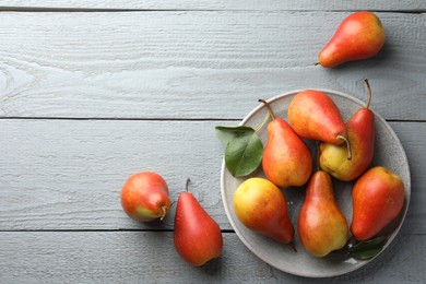 Photo of Ripe juicy pears on grey wooden table, flat lay. Space for text