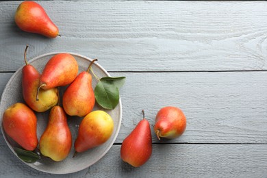 Photo of Ripe juicy pears on grey wooden table, flat lay. Space for text