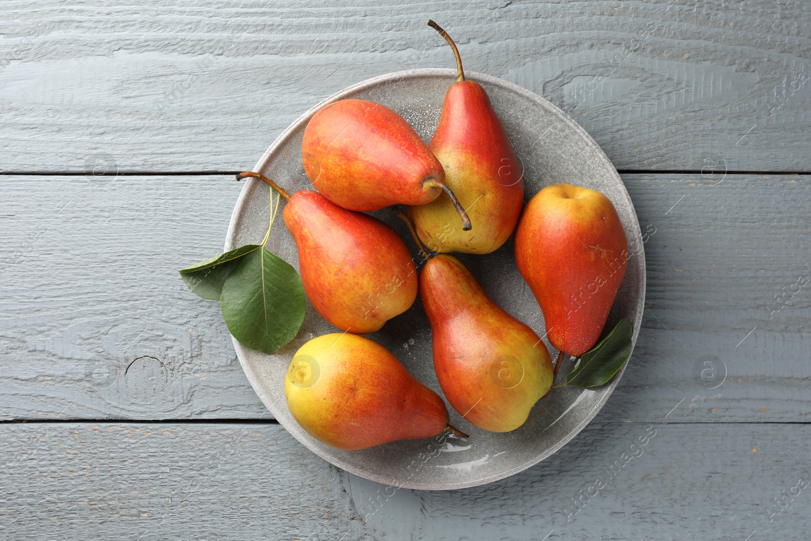 Photo of Ripe juicy pears on grey wooden table, top view