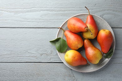 Photo of Ripe juicy pears on grey wooden table, top view. Space for text