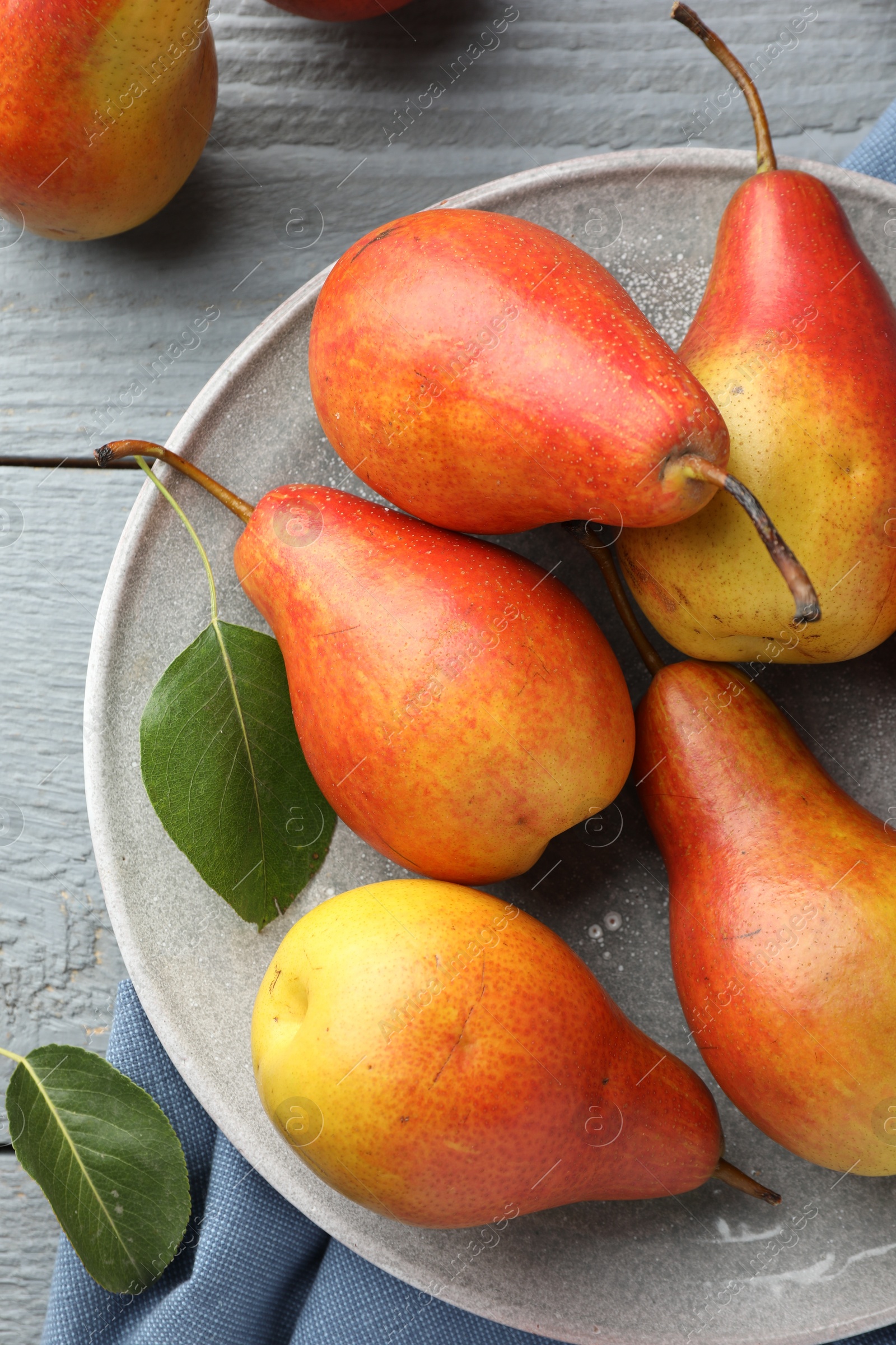 Photo of Ripe juicy pears on grey wooden table, top view