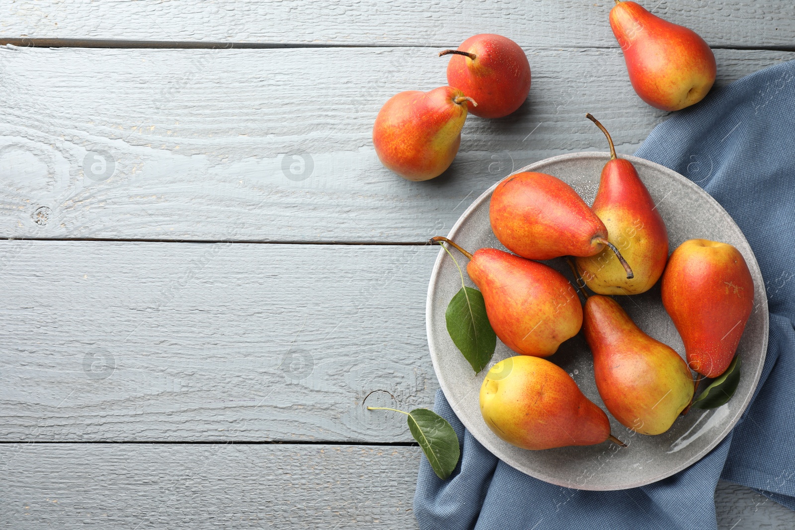 Photo of Ripe juicy pears on grey wooden table, flat lay. Space for text