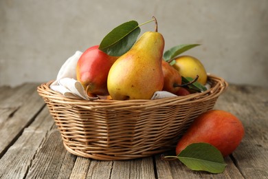 Photo of Ripe juicy pears in wicker basket on wooden table