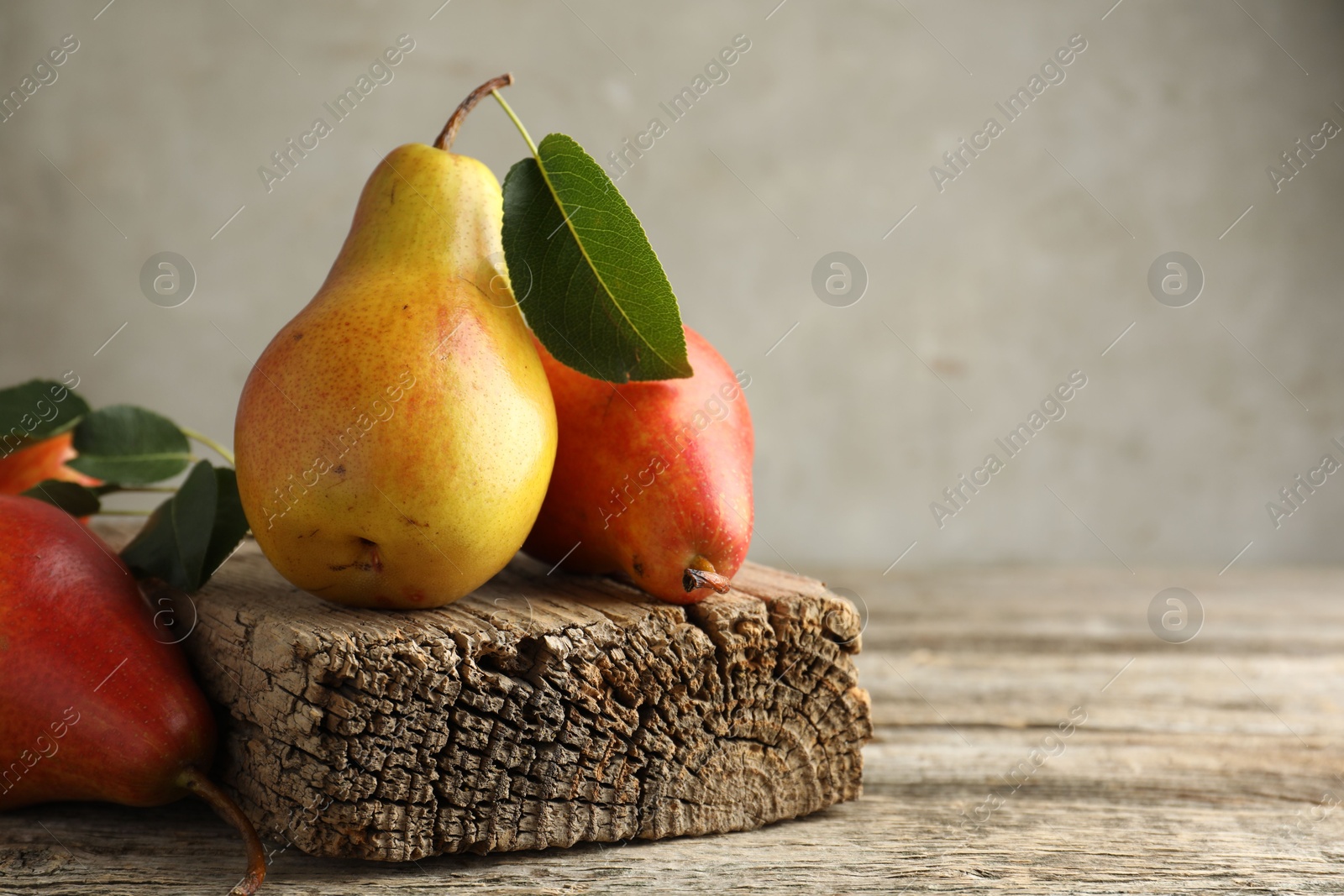 Photo of Ripe juicy pears on wooden table, space for text