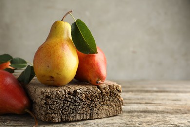 Photo of Ripe juicy pears on wooden table, space for text