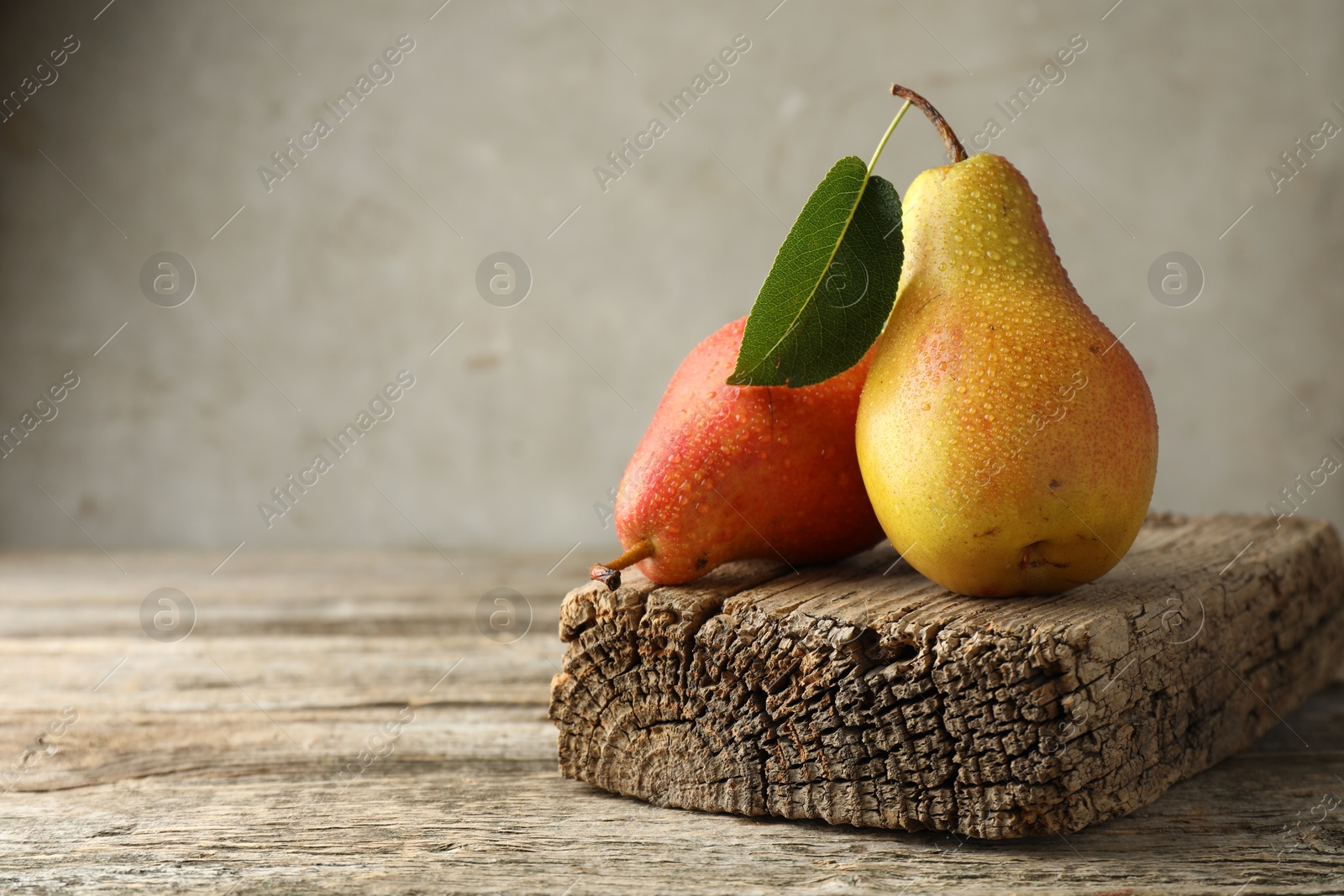 Photo of Ripe juicy pears drops on wooden table, space for text