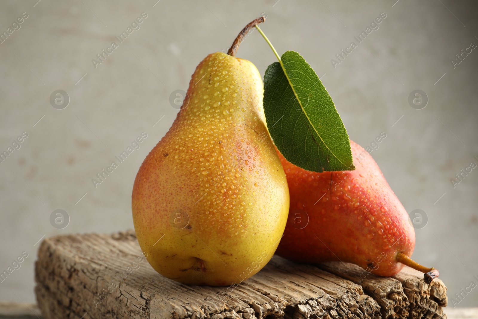 Photo of Ripe juicy pears on table against grey background, closeup