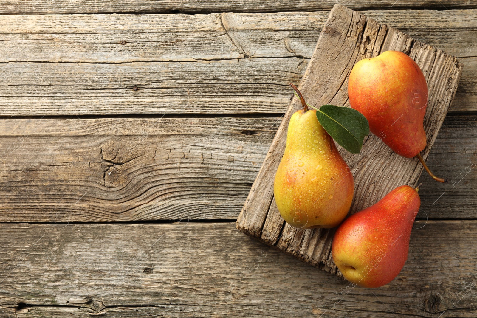 Photo of Ripe juicy pears on wooden table, top view. Space for text