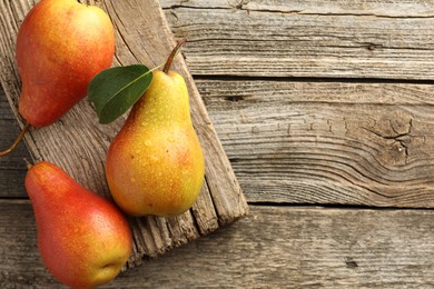 Photo of Ripe juicy pears on wooden table, top view. Space for text