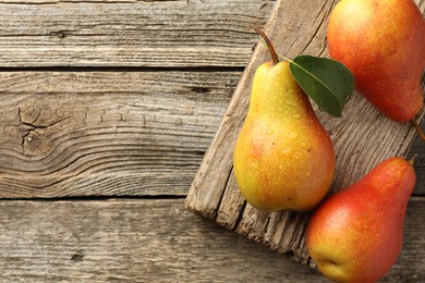 Photo of Ripe juicy pears on wooden table, top view. Space for text