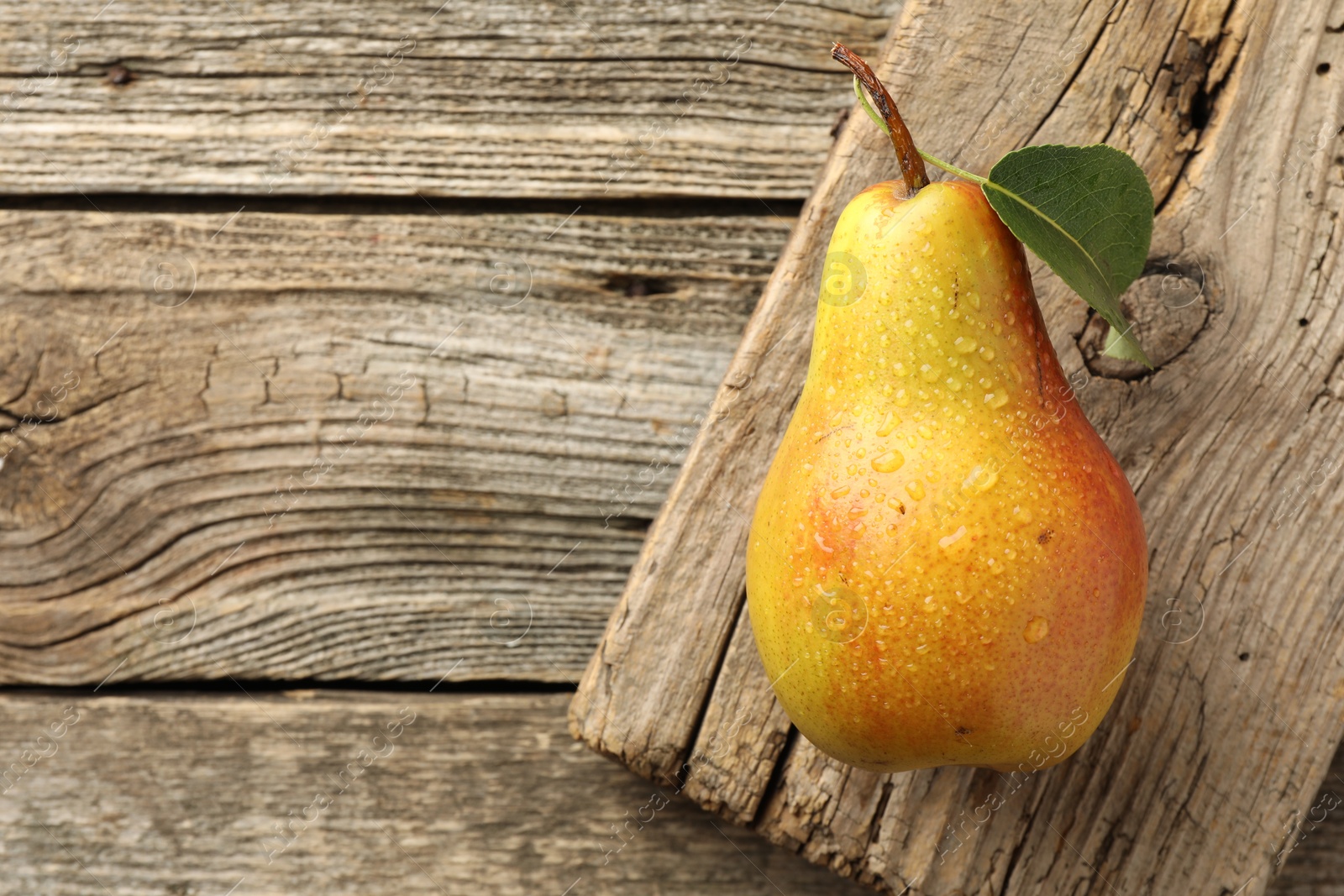 Photo of Ripe juicy pear on wooden table, top view. Space for text