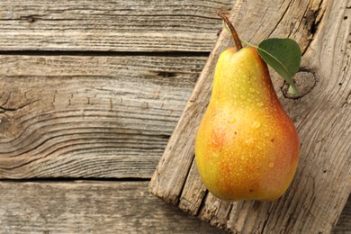 Photo of Ripe juicy pear on wooden table, top view. Space for text