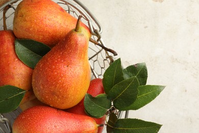 Photo of Ripe juicy pears in metal basket on grey table, top view