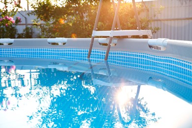 Photo of Above ground swimming pool in garden on sunny day, closeup