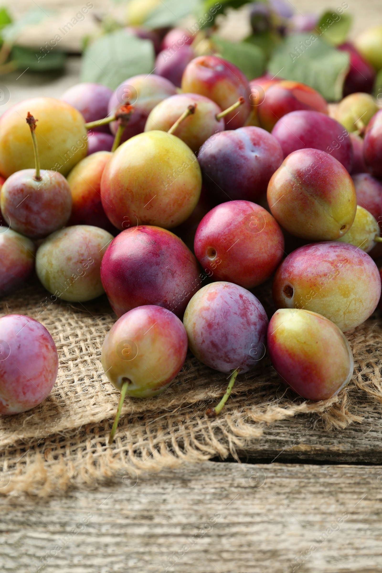 Photo of Pile of tasty ripe plums on wooden table