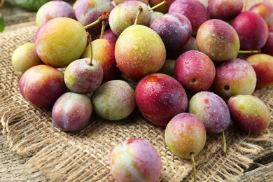 Photo of Pile of tasty ripe plums on table, closeup