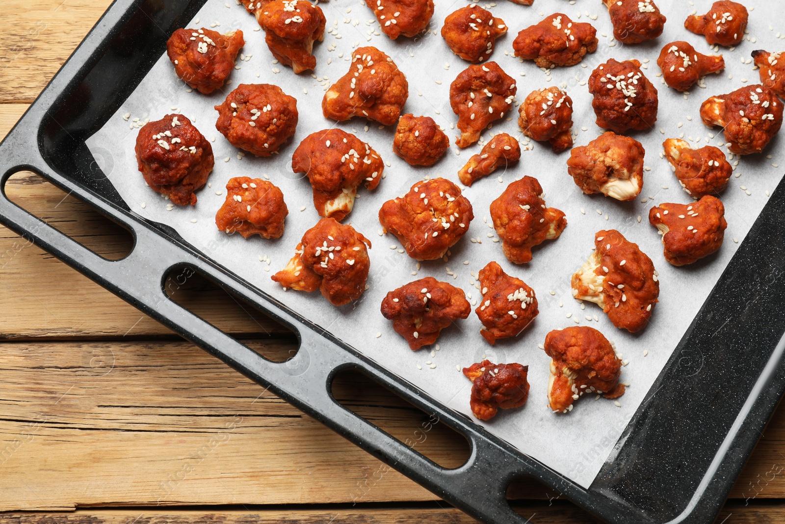 Photo of Tray with tasty cauliflower buffalo wings on wooden table, top view