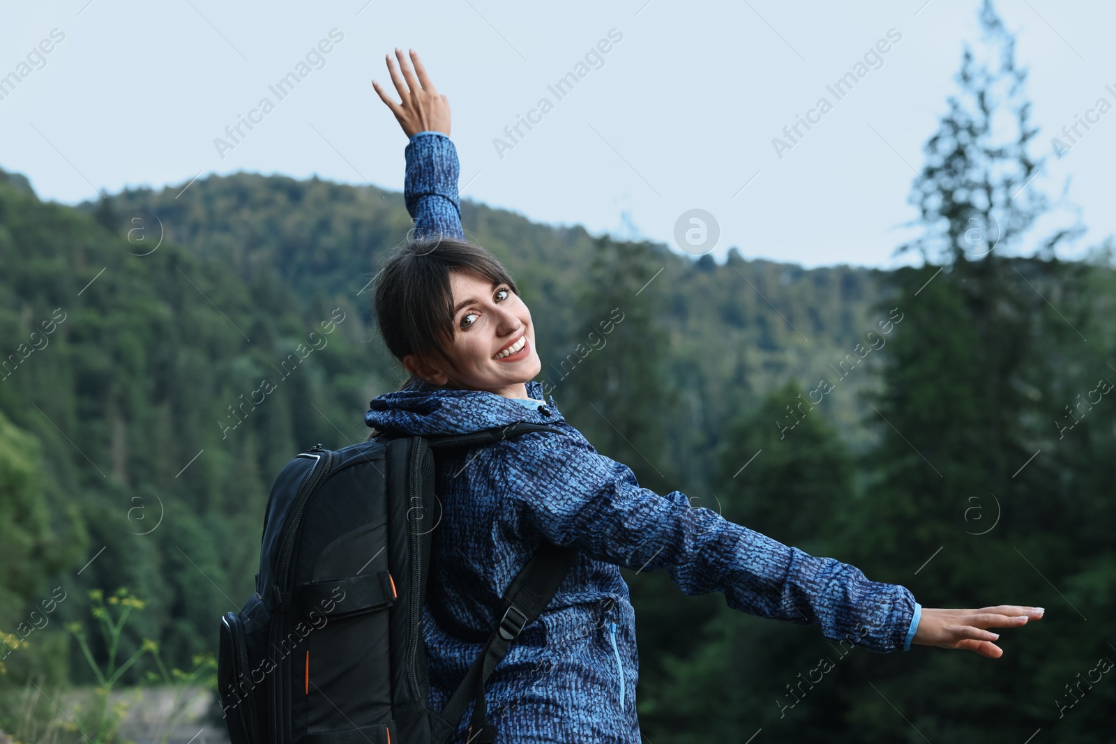 Photo of Smiling woman with backpack in beautiful mountains