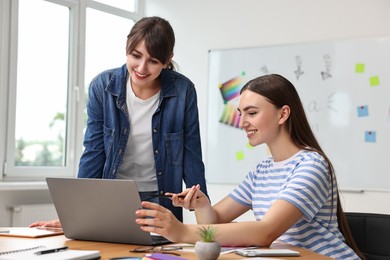 Happy young designers working together in office