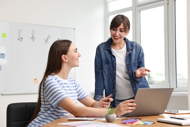 Happy young designers working together in office