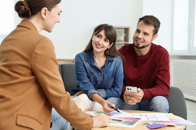 Designer discussing project with clients at table in office