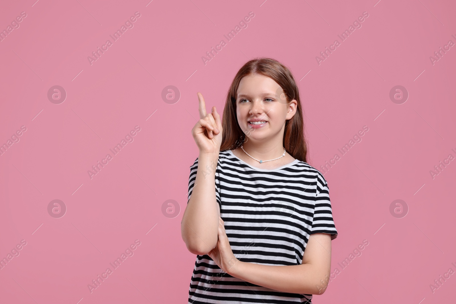 Photo of Portrait of teenage girl on pink background, space for text