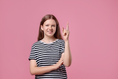 Photo of Portrait of teenage girl on pink background, space for text