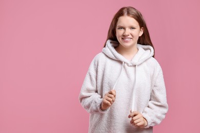 Portrait of teenage girl on pink background, space for text