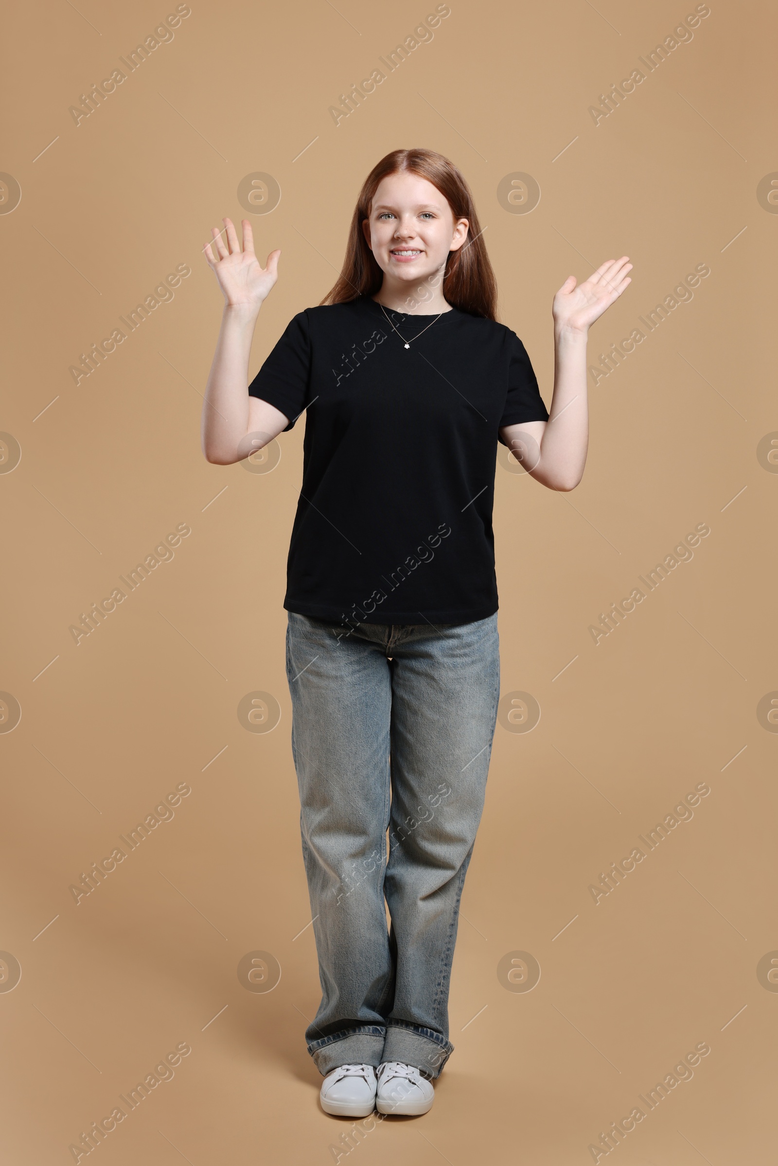 Photo of Full length portrait of teenage girl on beige background