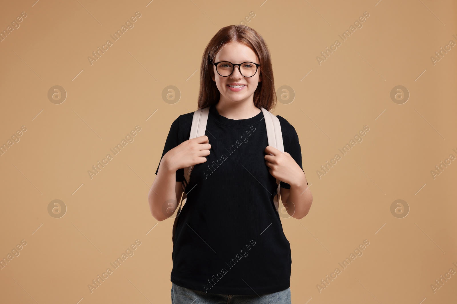 Photo of Teenage girl with backpack on beige background