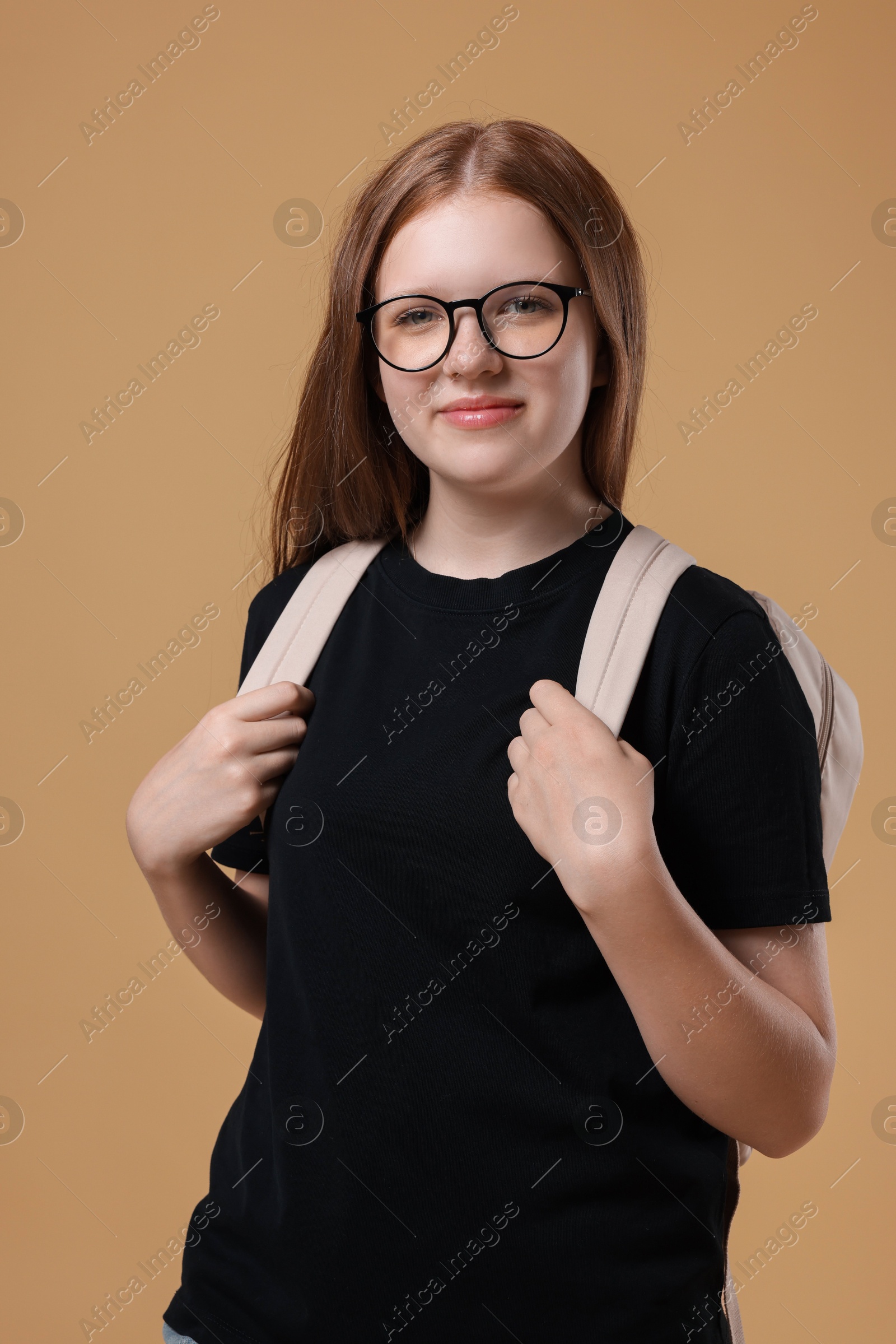 Photo of Teenage girl with backpack on beige background