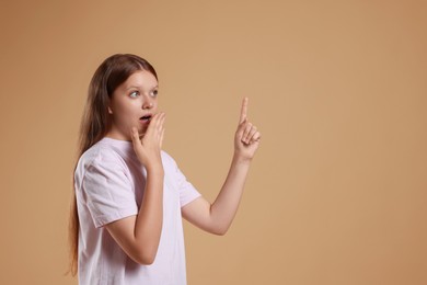 Portrait of teenage girl on beige background, space for text