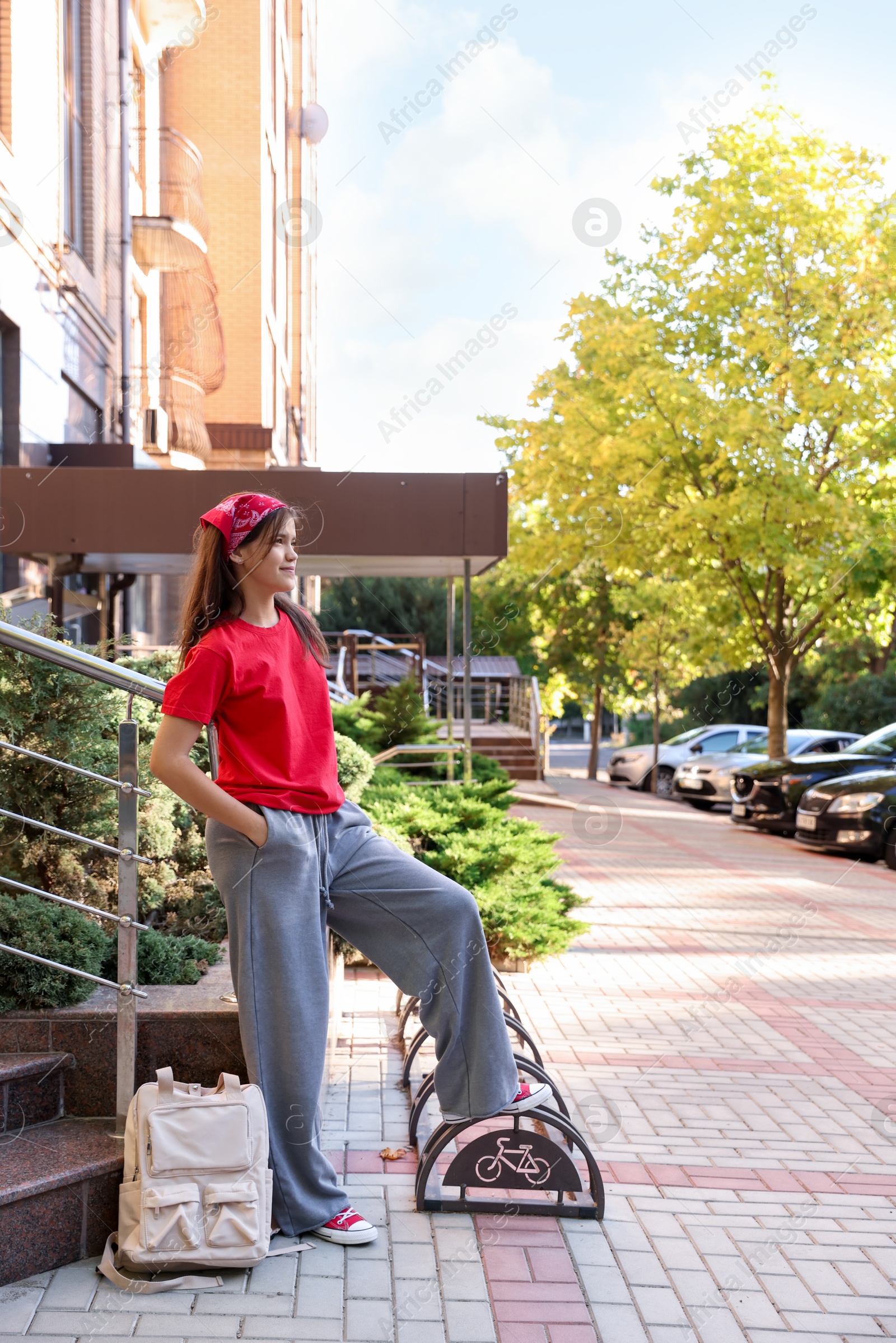 Photo of Cute teenage girl posing on city street