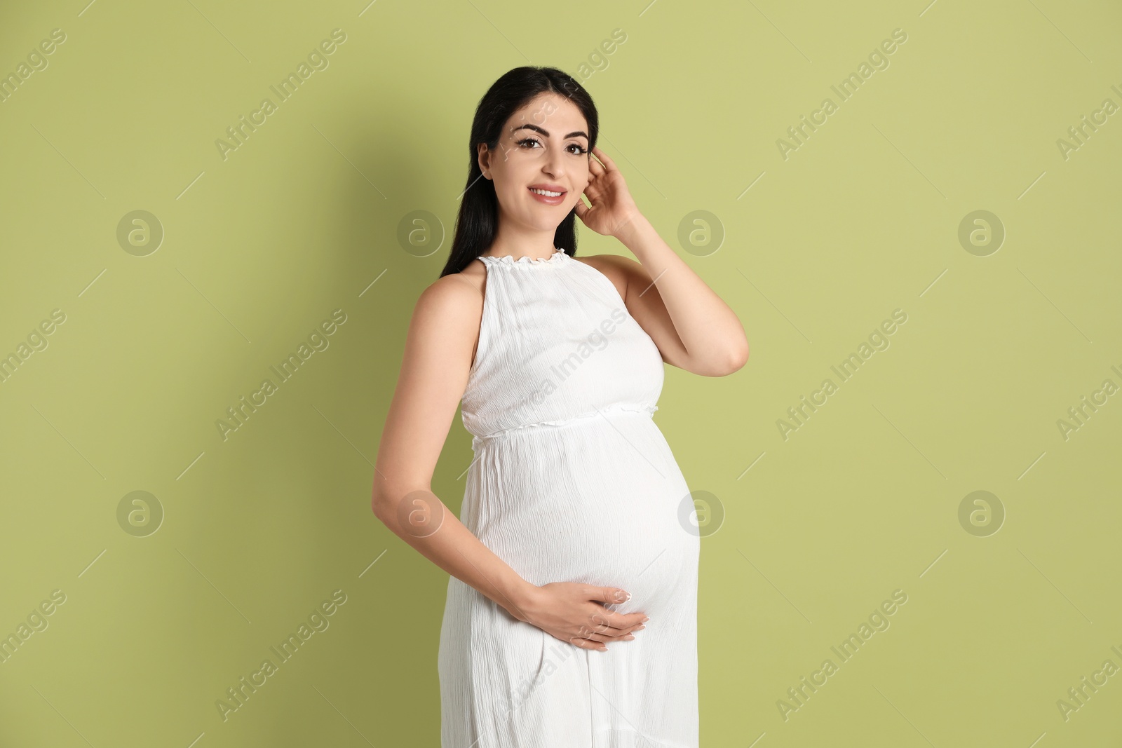 Photo of Portrait of beautiful pregnant woman on light olive background