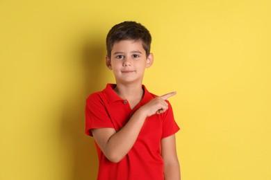 Photo of Portrait of cute little boy on yellow background