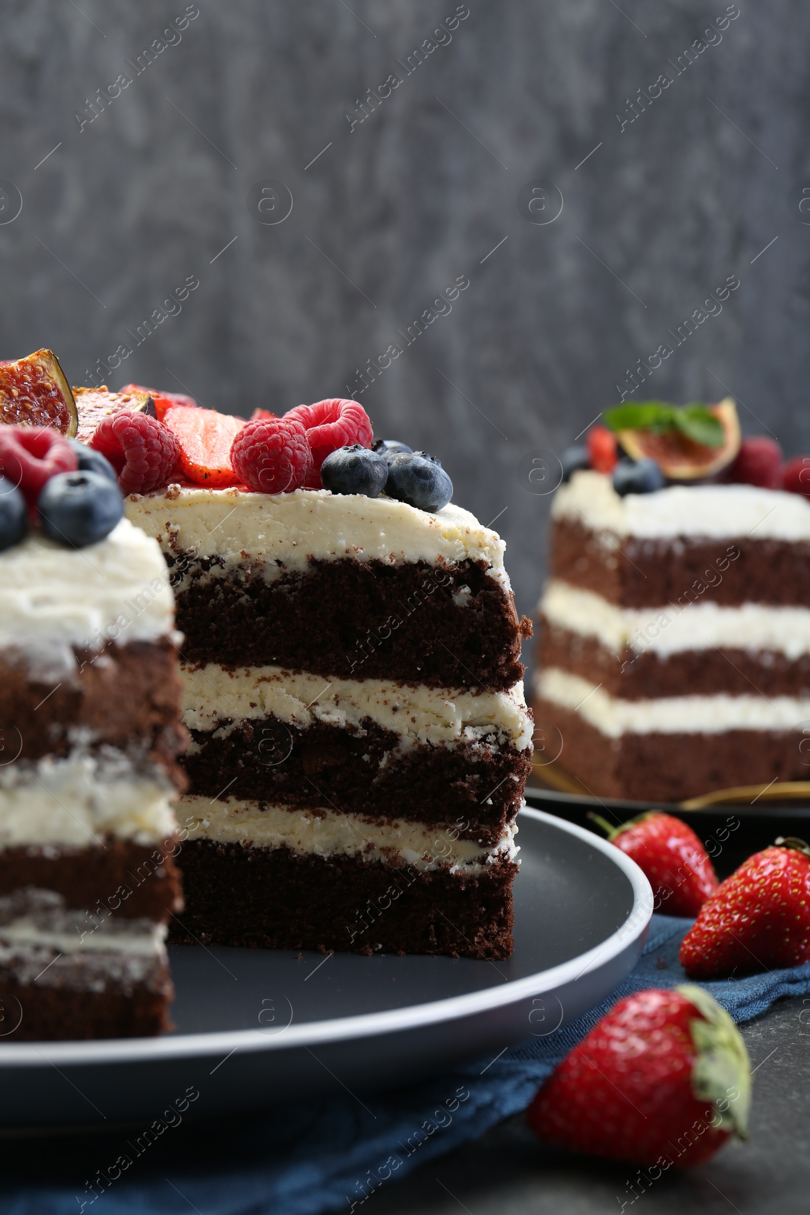 Photo of Delicious chocolate sponge cake with berries on table, closeup