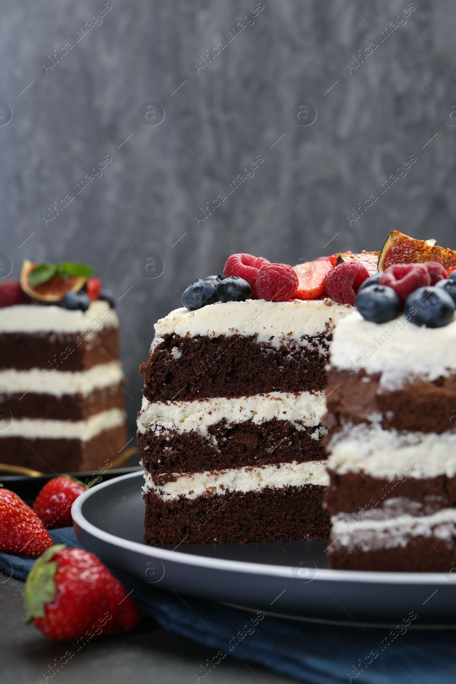 Photo of Delicious chocolate sponge cake with berries on table, closeup